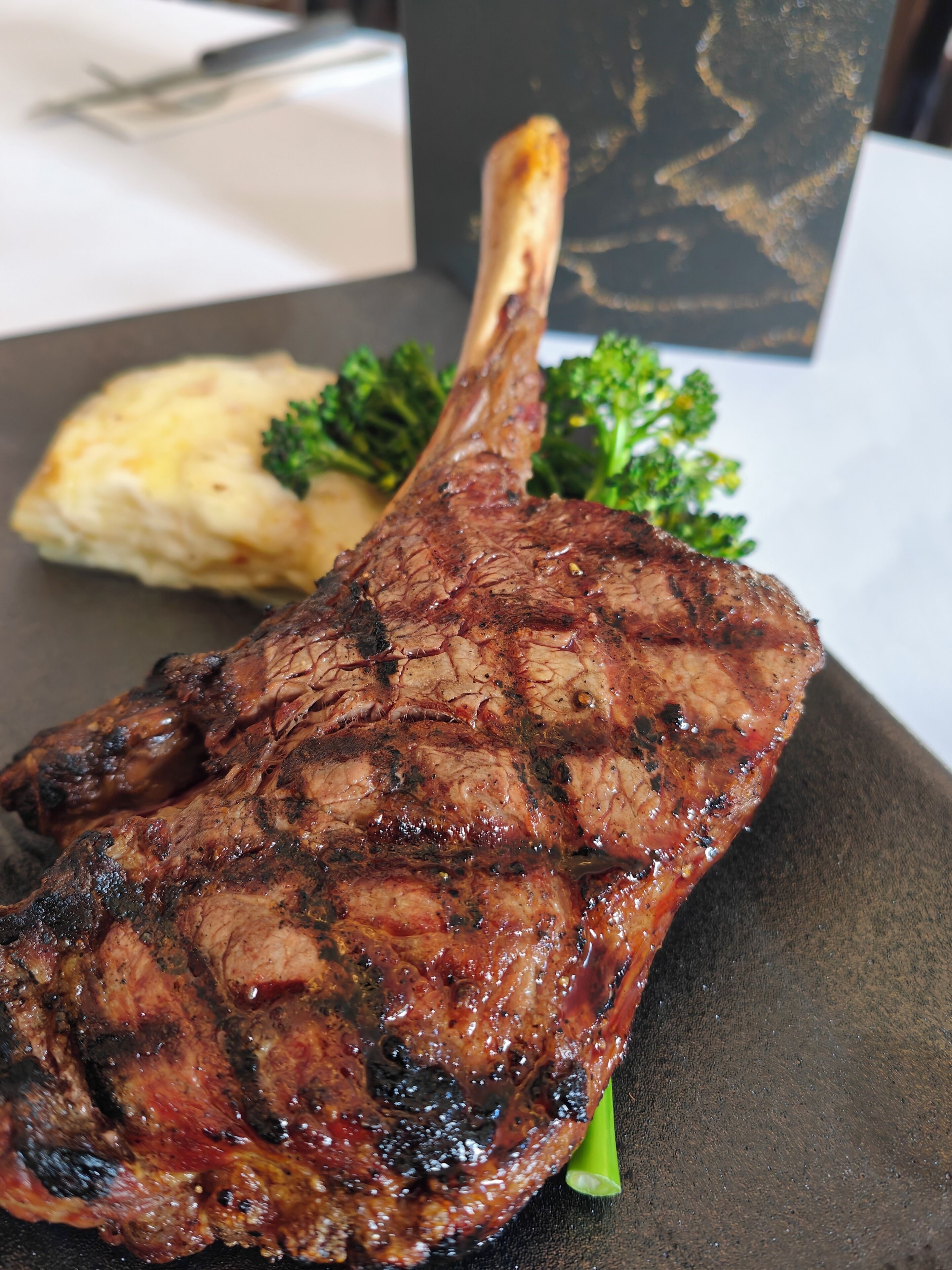 A grilled steak with a side of mashed potatoes and broccoli on a plate.