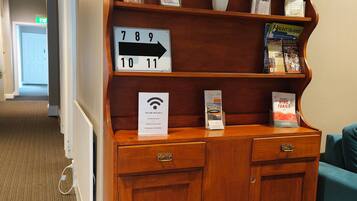 A wooden reception desk with a sign indicating room numbers 789 and 10-11.