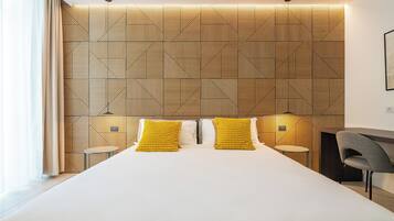 Camera d'albergo moderna con un letto grande, due comodini e una poltrona.