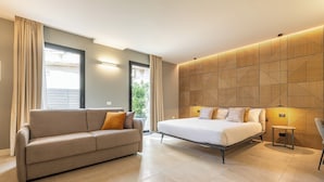 Une chambre à coucher moderne avec un lit, un canapé et un mur décoré d’un motif.