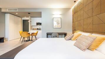 Una habitación de hotel moderna con una cama grande, un escritorio y una kitchenette.