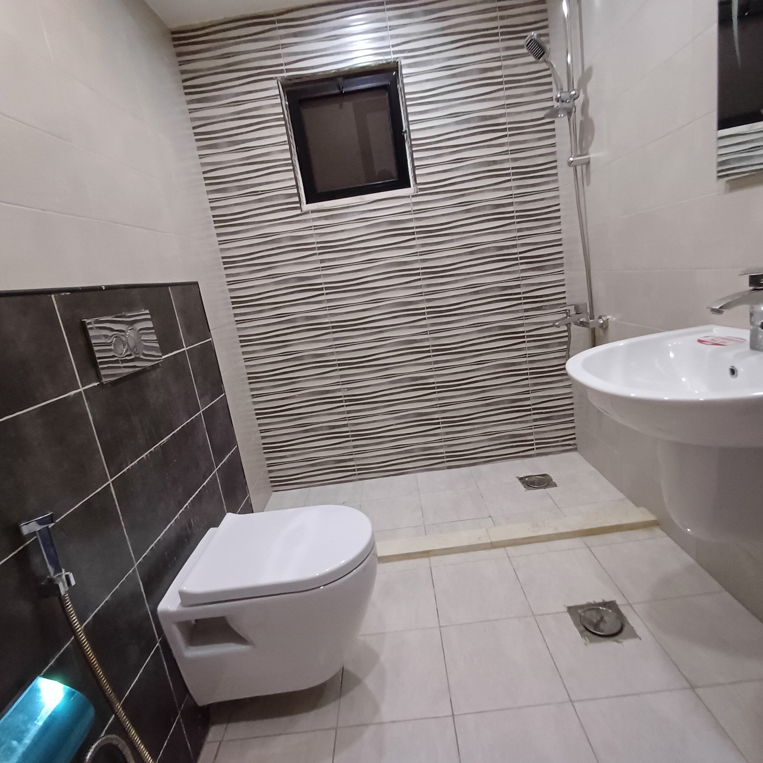 A bathroom with a white toilet, a sink, and a shower.