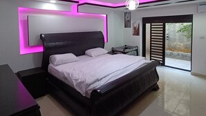 Une chambre moderne avec un grand lit, un bureau et un balcon offrant une vue agréable.