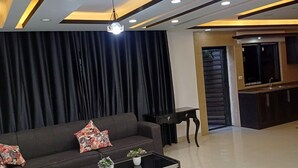 Un salon moderne avec un canapé d’angle, une table basse et un téléviseur.