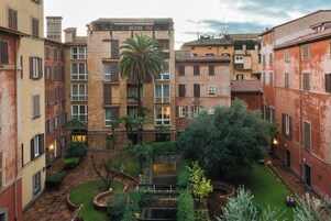 Un patio central con una escalera, rodeado por edificios de varios pisos con balcones y ventanas.
