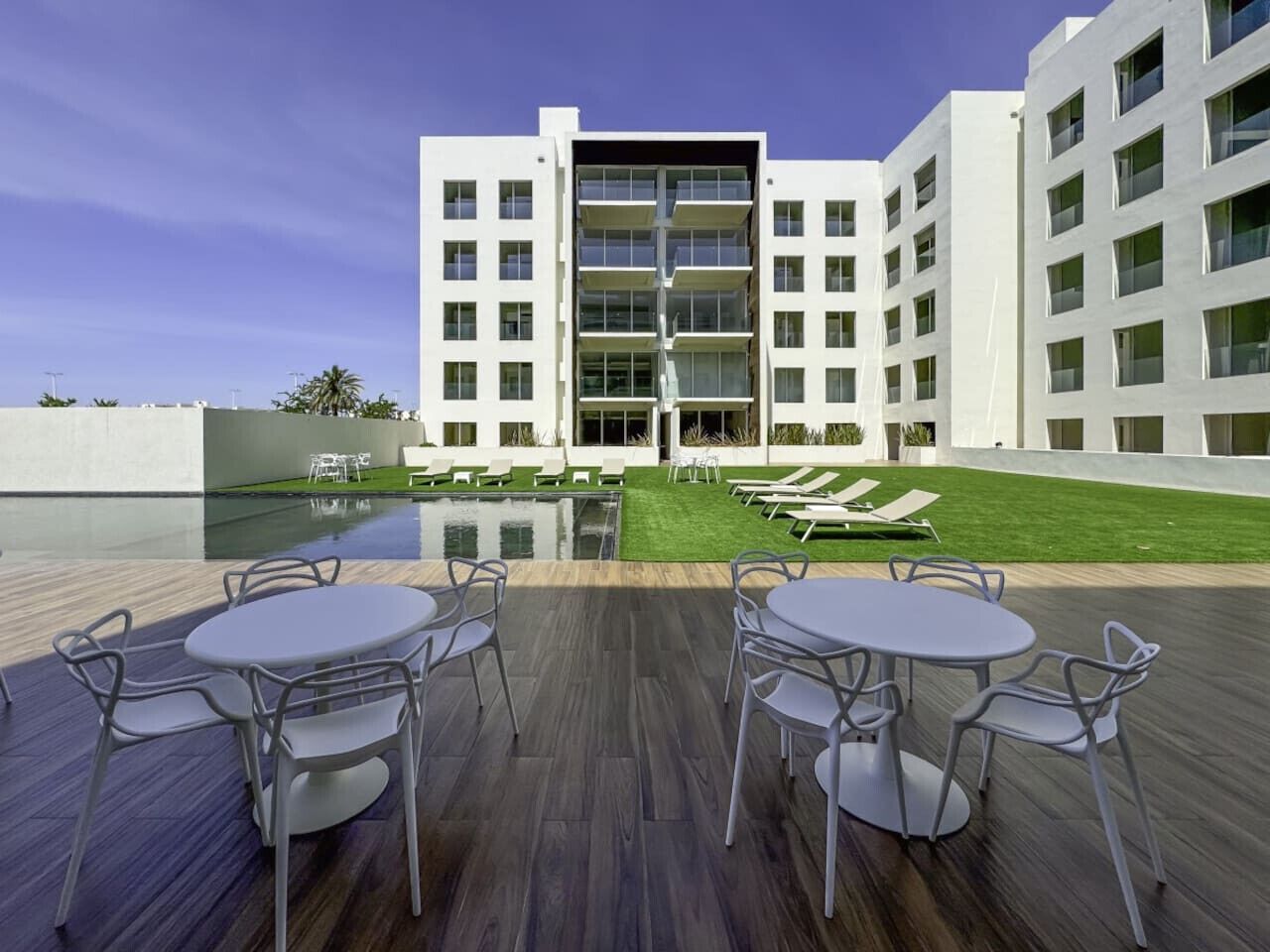 Een modern gebouw met een zwembad en een terras.