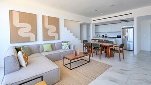 Una sala de estar moderna con un sofá, una mesa de centro y una obra de arte en la pared.