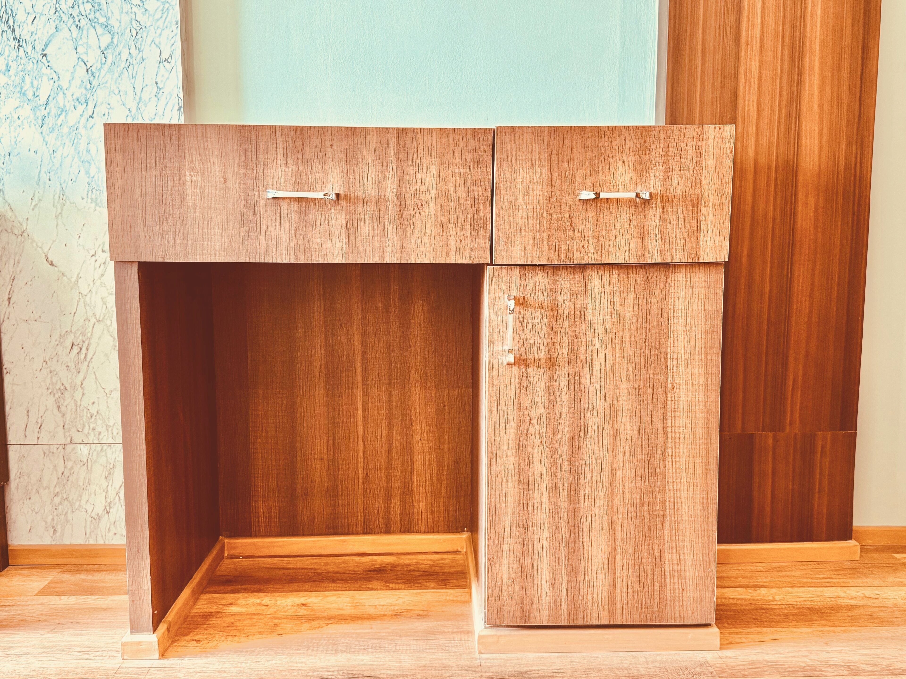 Un bureau en bois doté de deux tiroirs et d’un meuble à part avec un seul tiroir.