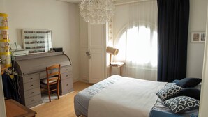 A bedroom with a bed, a desk, and a chair. - Apt with garden and parking on the banks of the Seine in front of the cathedral (Rouen)