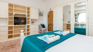 A bedroom with a bed, a TV, a chair, and a wardrobe. - Villa Monchique Royal (Monchique)