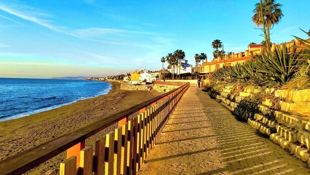 A coastal walkway with a wooden fence, leading to a beach with a clear view of the ocean. - Coastal Retreat-sleeps 8, Sea View, Pool & Parking (Estepona)