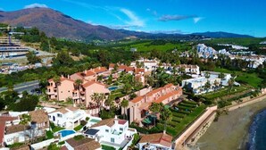 A coastal town with residential buildings, a beach, and mountains in the background. - Coastal Retreat-sleeps 8, Sea View, Pool & Parking (Estepona)