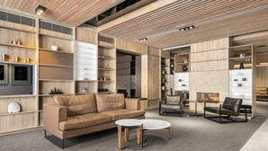 Een modern interieur met een bank, salontafel en stoelen, houten planken en een televisie.