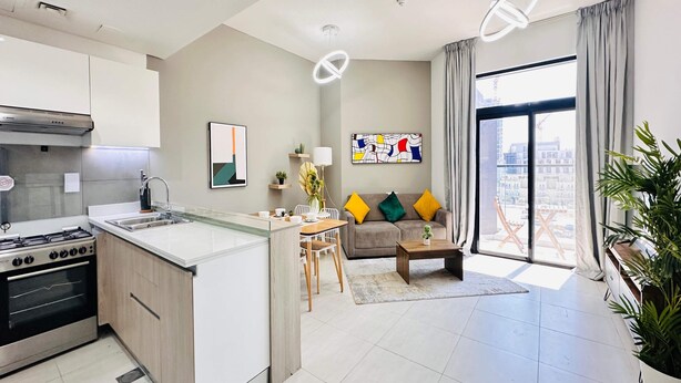 A modern apartment with a kitchen, dining area, and living room.