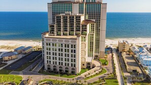 A high-rise hotel with multiple floors, large windows, and a curved corner design.