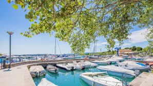A marina with boats docked, a lamp post, and a clear sky. - Marina Loft (Moniga del Garda)
