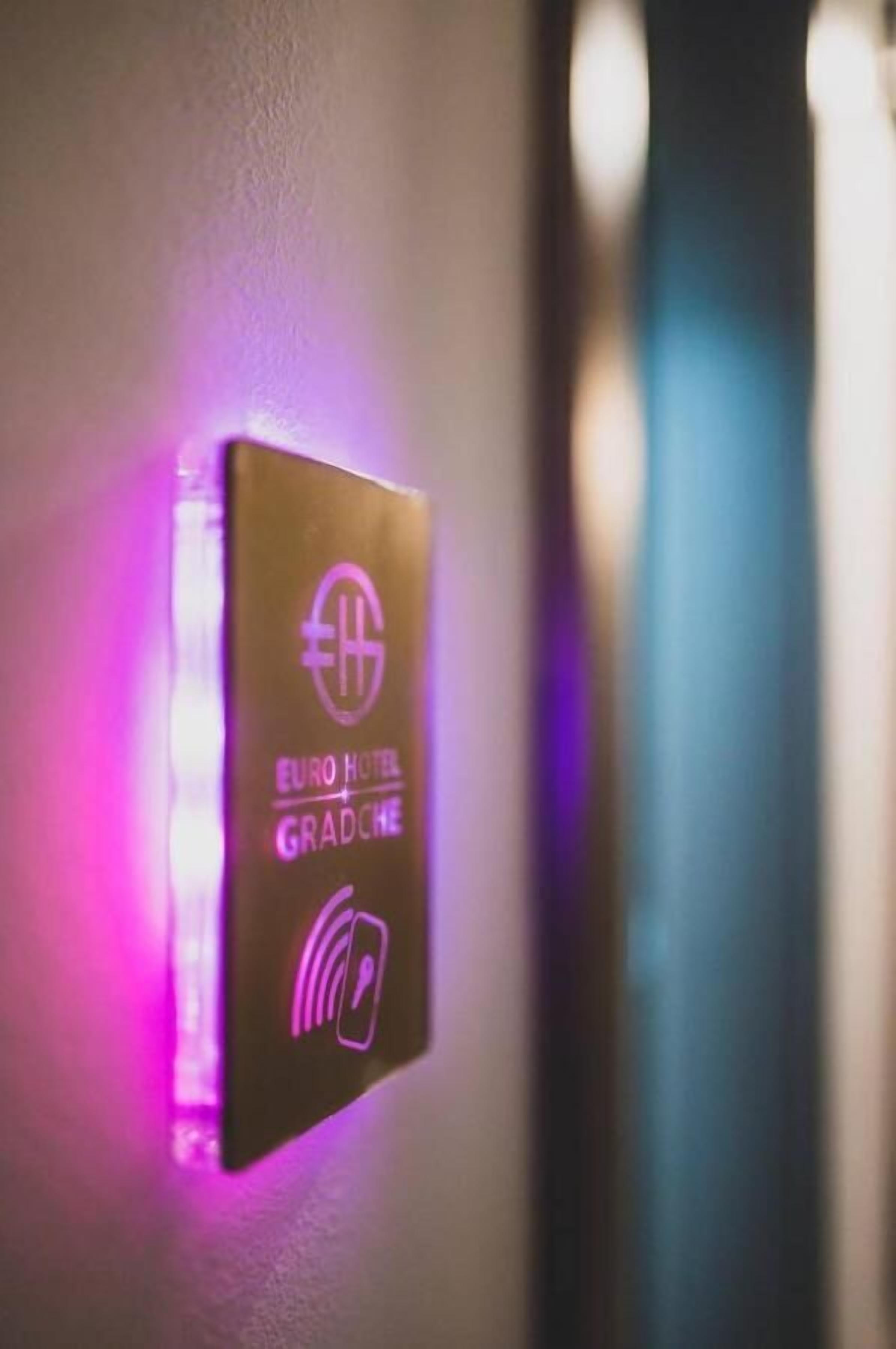 A wall-mounted device with the Euro Hotel Gradče logo and a symbol indicating a room service feature.