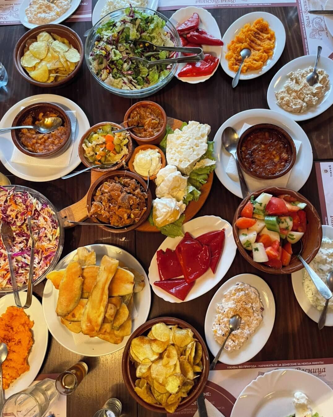 A table with various dishes including salads, soups, and bread.