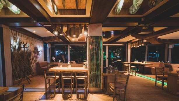 A modern interior with wooden beams, a high ceiling, and a bar area with seating. - Eurohotel Gradce - Hotel Brana Gradce (Dolno Gradche)