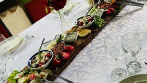 A long dining table set with various dishes, glasses, and cutlery, indicating a formal dining setup. - Eurohotel Gradce - Hotel Brana Gradce (Dolno Gradche)
