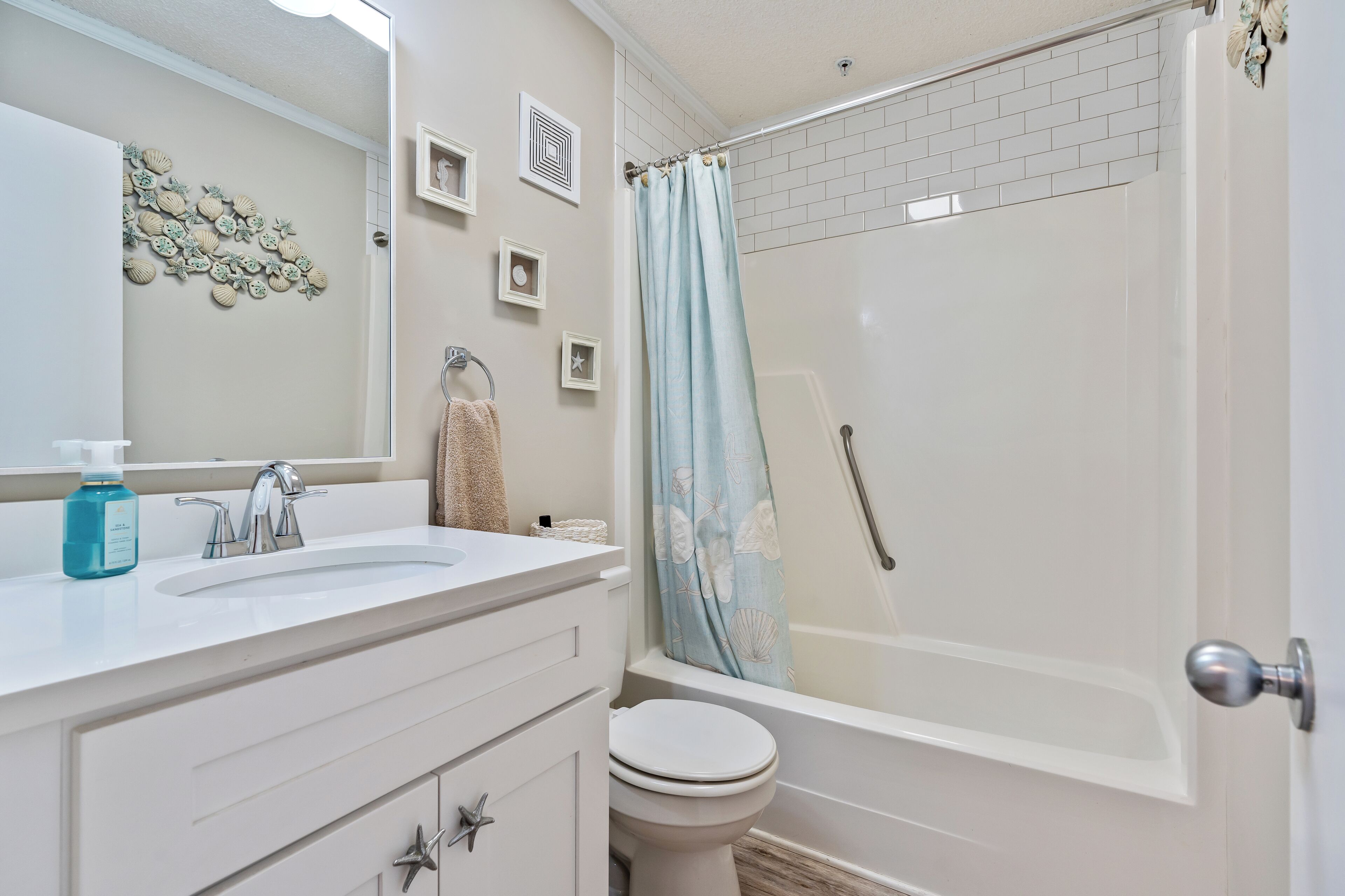 Un bagno con un lavandino bianco, due specchi, un water e una doccia con tenda.