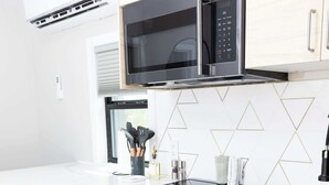 A modern kitchen with a microwave, stove, oven, and sink. - Container Home @ Stardust Big Bend 5 min from Park (Terlingua)