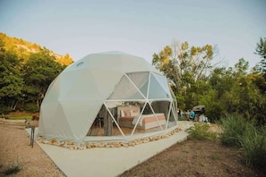 A geodesic dome structure with a bed and a table inside. - Dome Retreat Near Zion. Hot Tub and Sauna. (Glendale)