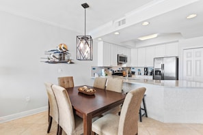 A modern kitchen with white cabinets, stainless steel appliances, and a central island. - San Carlos 705 (Gulf Shores)