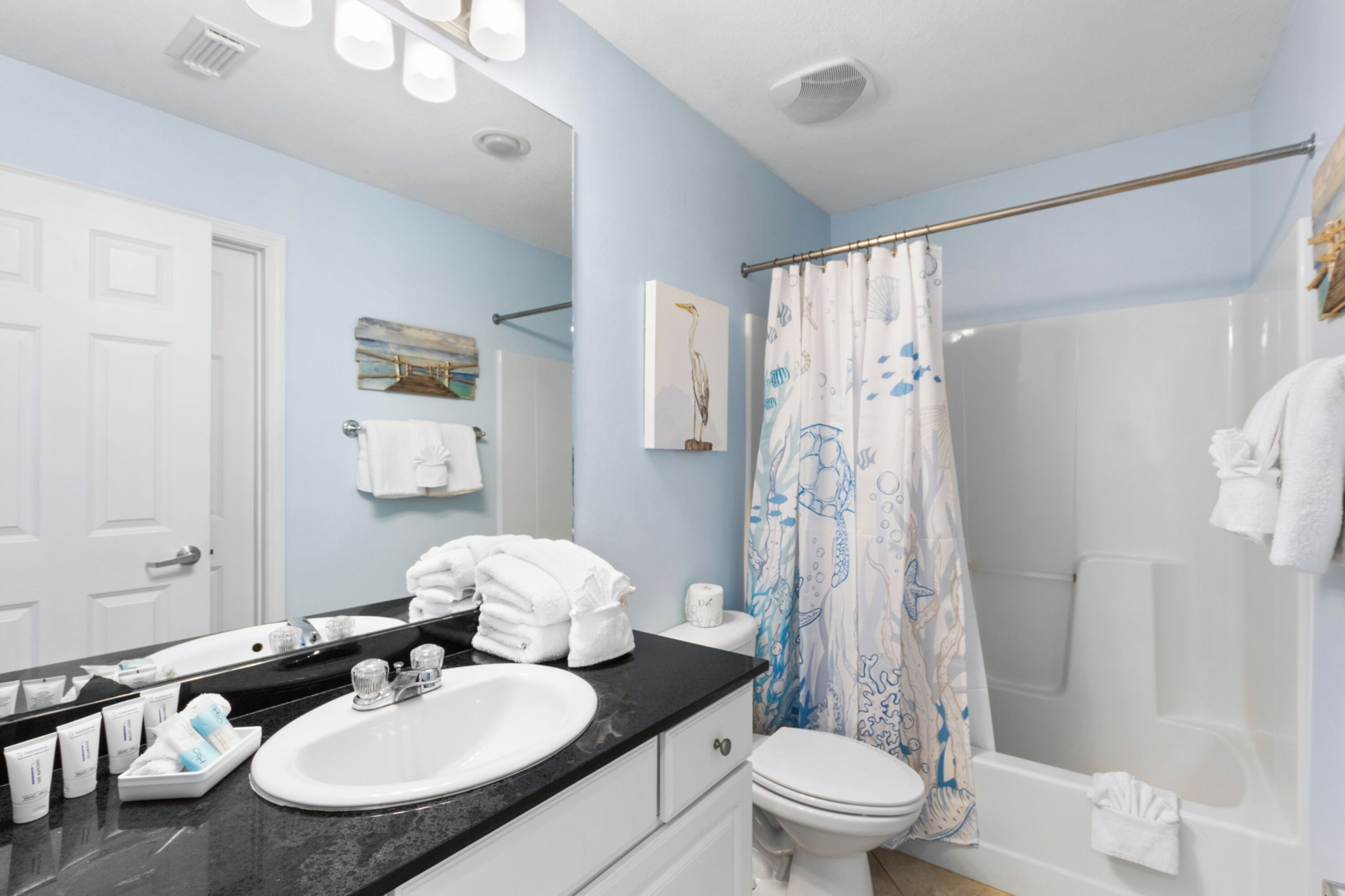 A bathroom with a sink, toilet, and shower curtain.