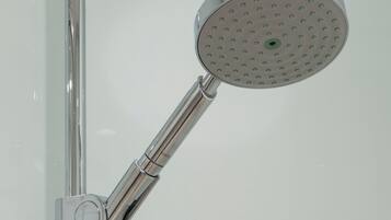 Un cabezal de ducha cromado con diseño circular y una sola palanca.