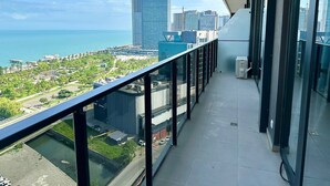 A balcony with a city view, including a body of water and high-rise buildings. - Nova Concierge (Batumi)