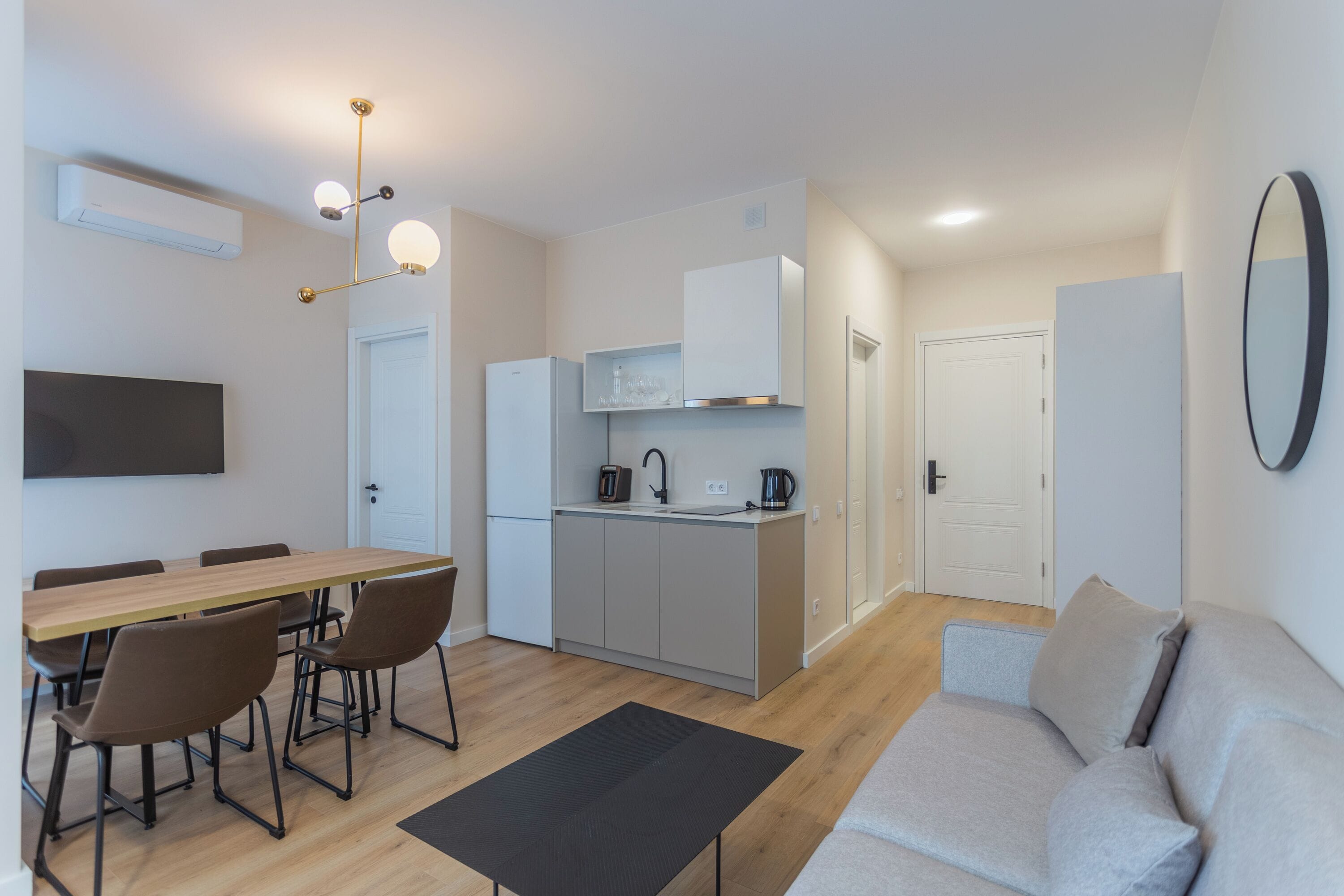 Una cucina moderna con zona pranzo, divano e televisore a schermo piatto.