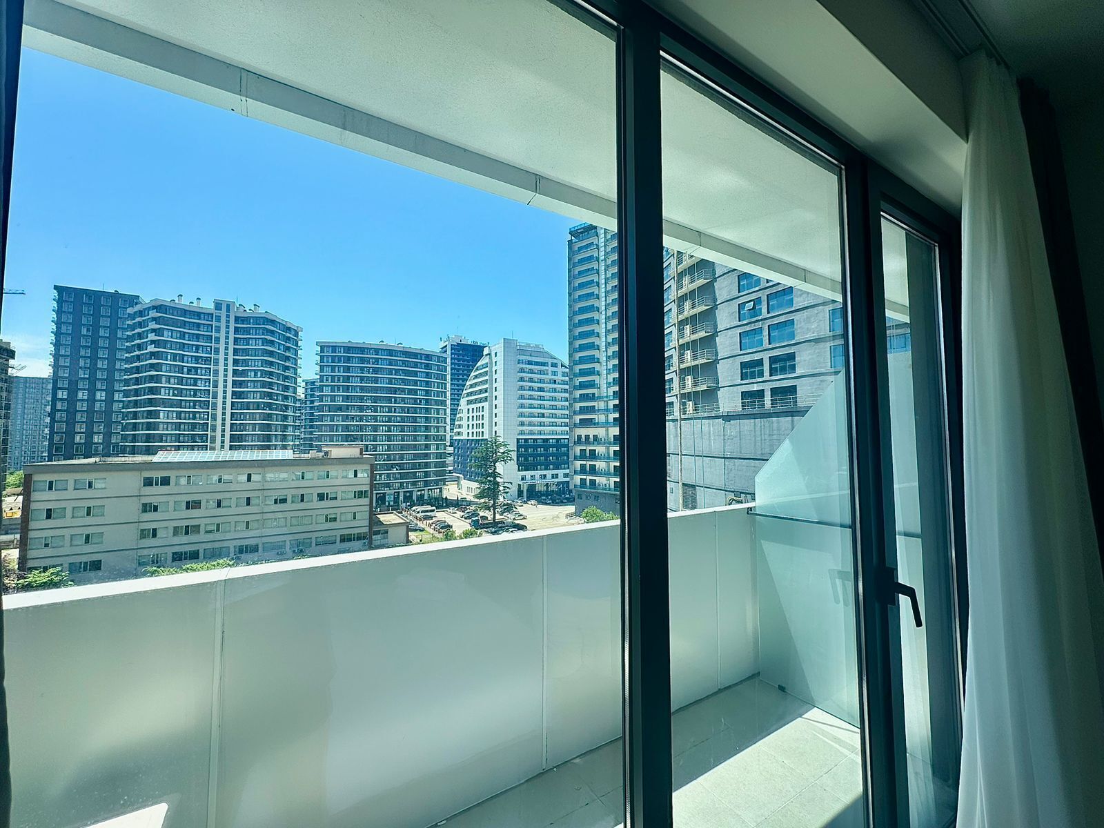 Ein Balkon mit Blick auf hohe Gebäude.