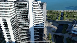 A high-rise building with multiple balconies and a view of the sea. - Nova Concierge (Batumi)