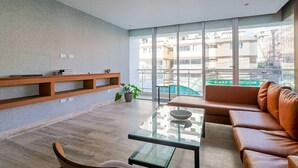 Ein modernes Wohnzimmer mit einem Glastisch, einer Ledersofa und eingebauten Holzbögen.