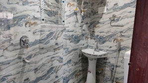 Ein Badezimmer mit Marmorwänden, einem Standwaschbecken und einer Toilette.