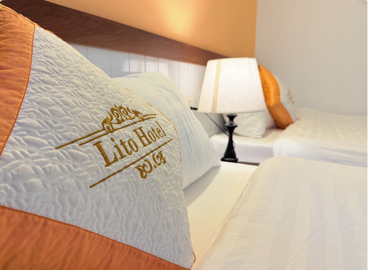 Une chambre d’hôtel avec un lit, des oreillers et une lampe de chevet.