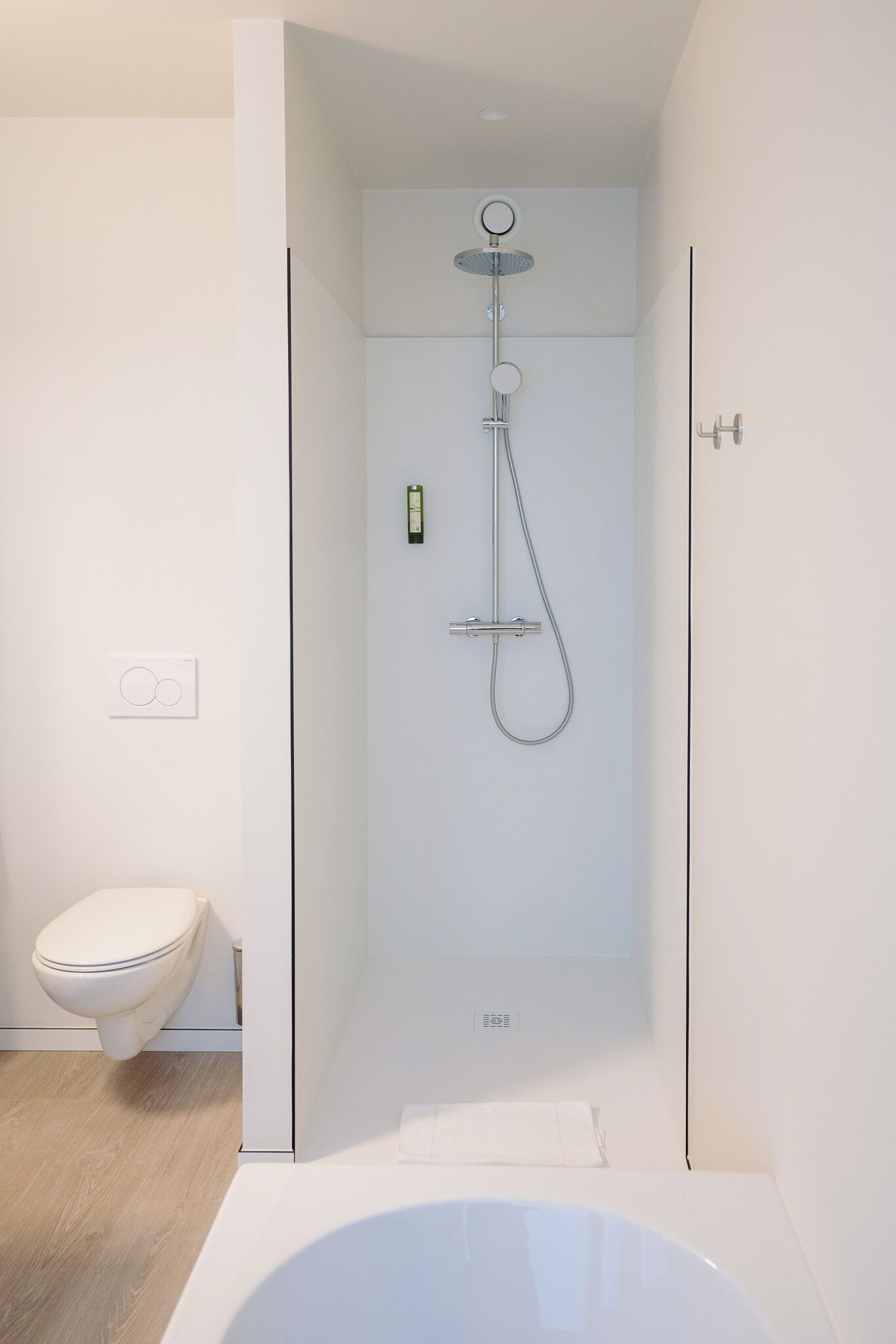 A modern bathroom with a glass-enclosed shower, a white toilet, and a bathtub.