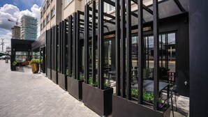 A modern building with a glass facade and outdoor seating area. - Hotel du Bassin (Ostend)