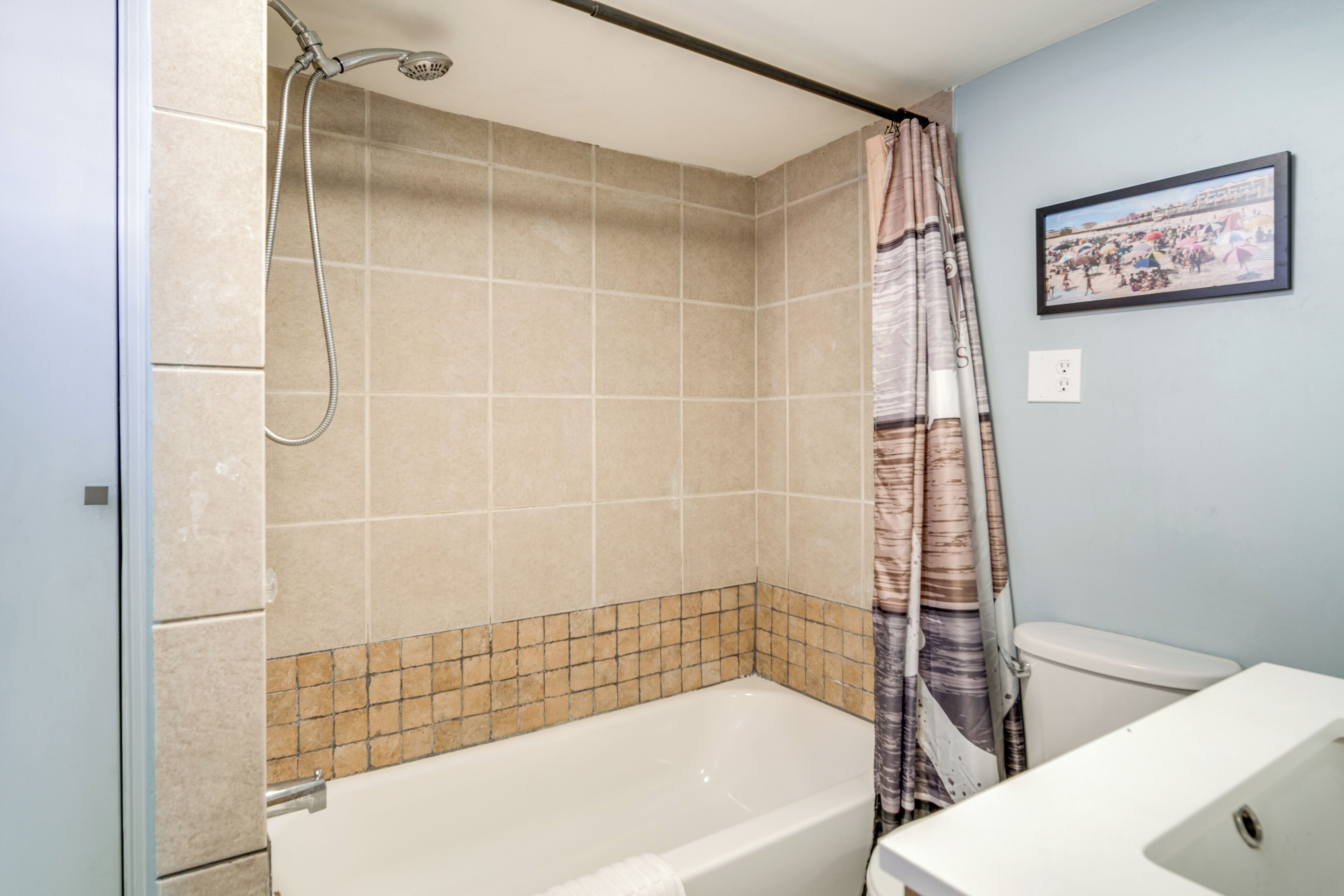 A bathroom with a bathtub, shower, and toilet.