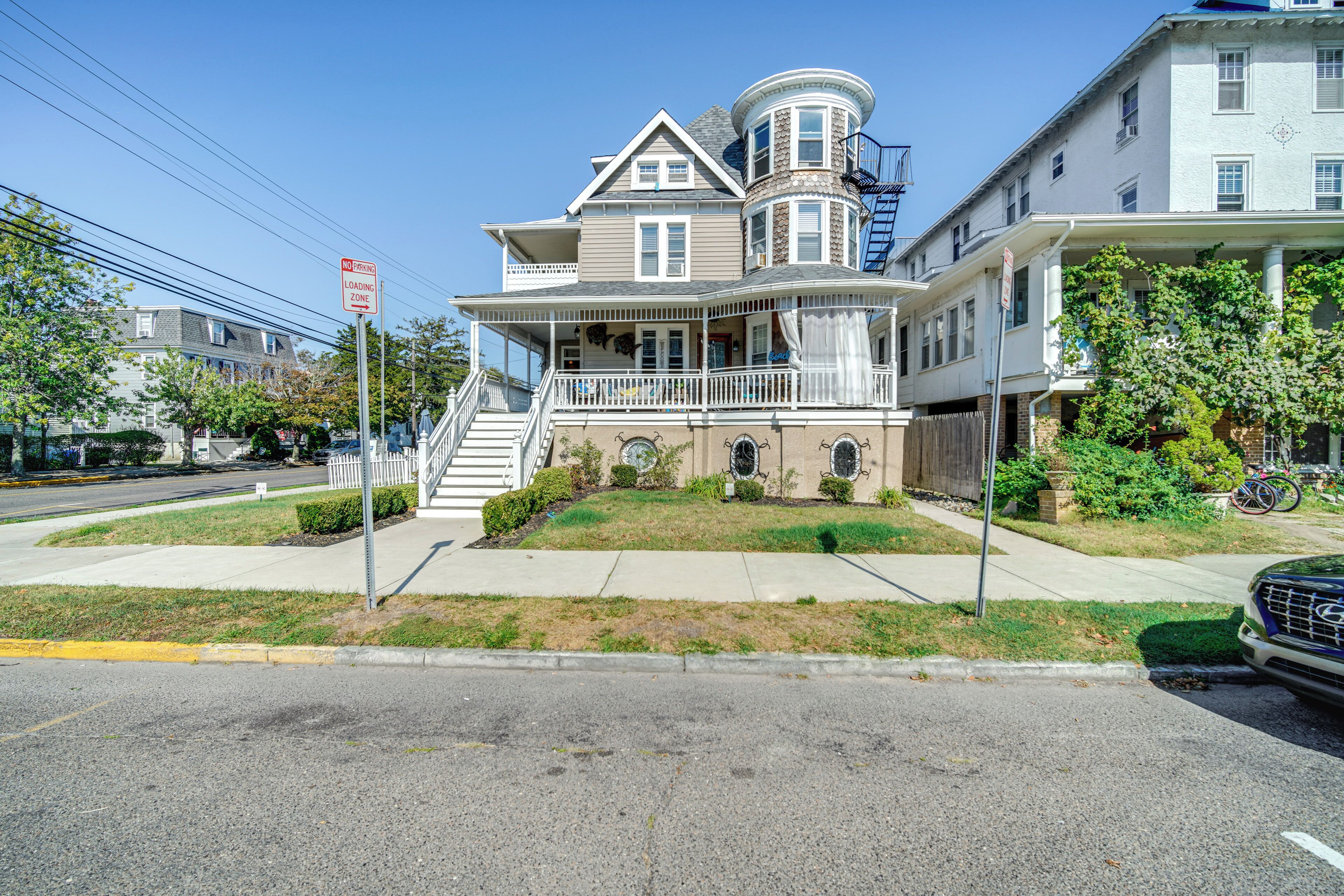 A two-story house with a wrap-around porch, a bay window, and a small front yard.