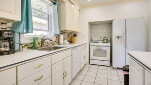 A kitchen with white cabinets, a sink, a stove, and a refrigerator. - 4 Mi to Nyc, Shared Yard: Englewood Apartment! (Englewood)