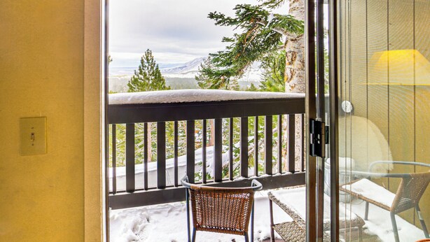 A glass door leading to a balcony with a view of snow-covered trees and mountains. - Walk to Ski Lift: Mtn-view Condo in Mammoth Lakes (Mammoth Lakes)