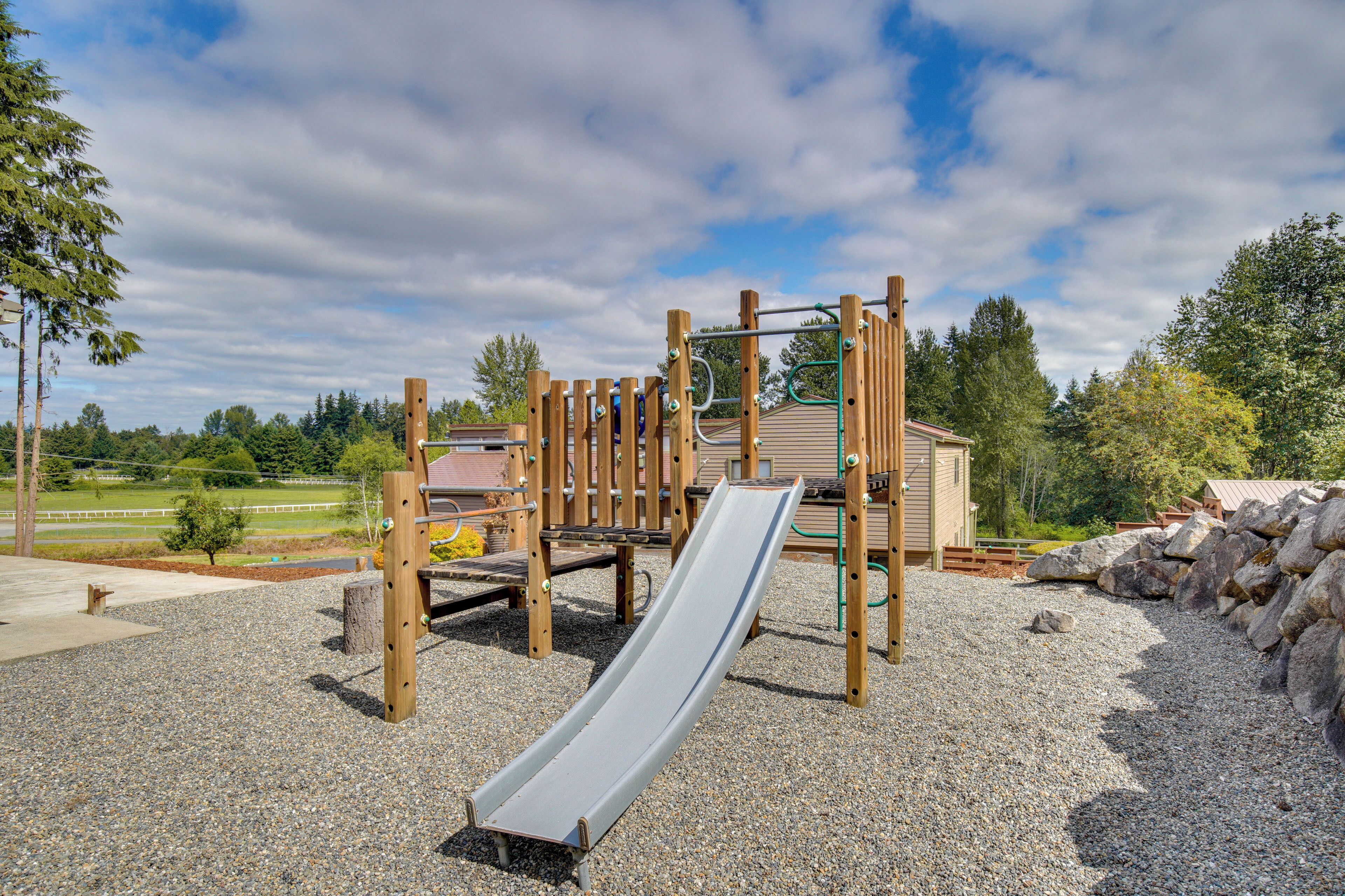 A playground with a slide, climbing structures, and a small shelter.