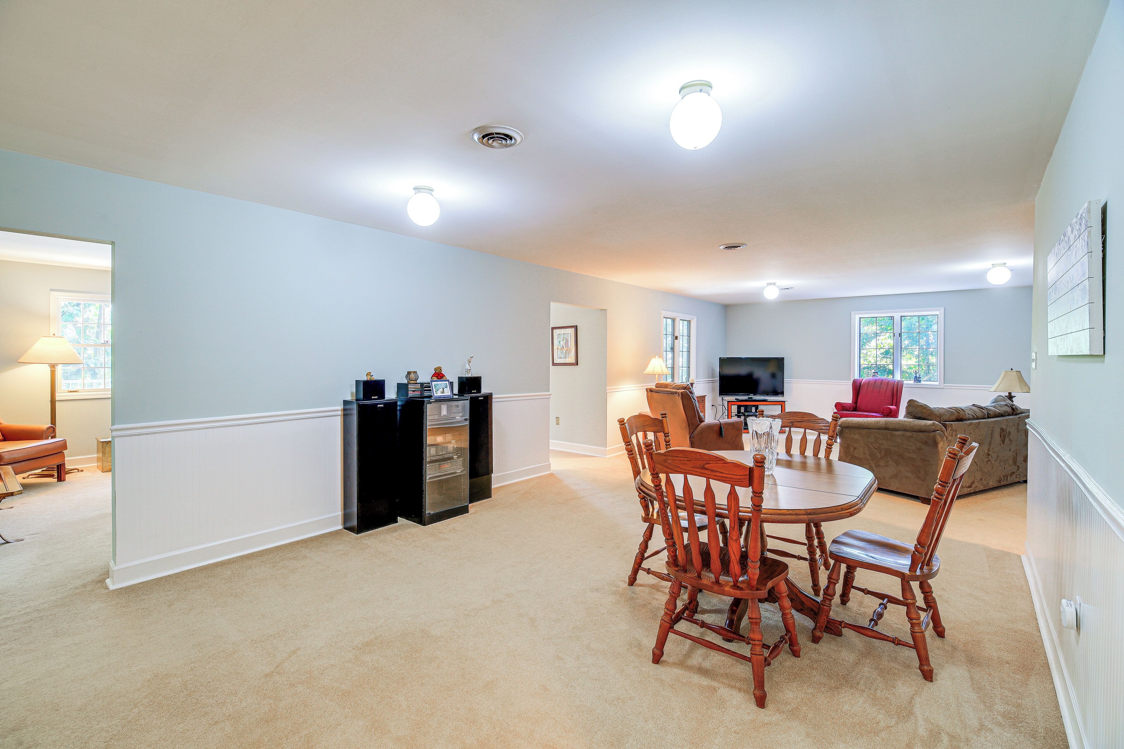 A spacious living room with a dining area, a kitchen, and a television.