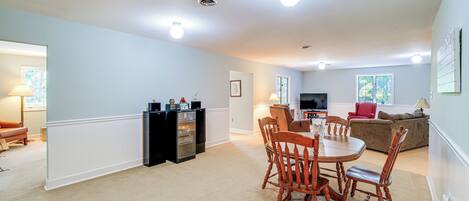 A spacious living room with a dining area, a kitchen, and a television.