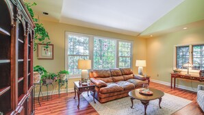 A living room with a leather sofa, wooden flooring, a coffee table, and a fireplace. - Spacious Home w/ Hiking Trail Access in Bristol! (Bristol)
