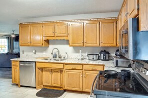 A kitchen with wooden cabinets, a dishwasher, a stove, and a microwave. - Game Room, 20 Mi to Nashville: Smyrna Home (Smyrna)