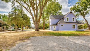 A two-story house with a grey roof and blue siding, surrounded by trees and a gravel driveway. - Walk to Winery: Holt Home 8 Mi to State Park! (Holt)