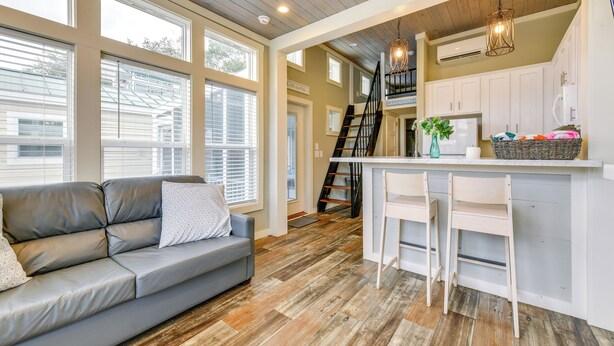 A modern kitchen with a central island, white cabinets, and a staircase leading to an upper level. - Lake Norman Getaway w/ Pool Access + Kayaking! (Sherrills Ford)